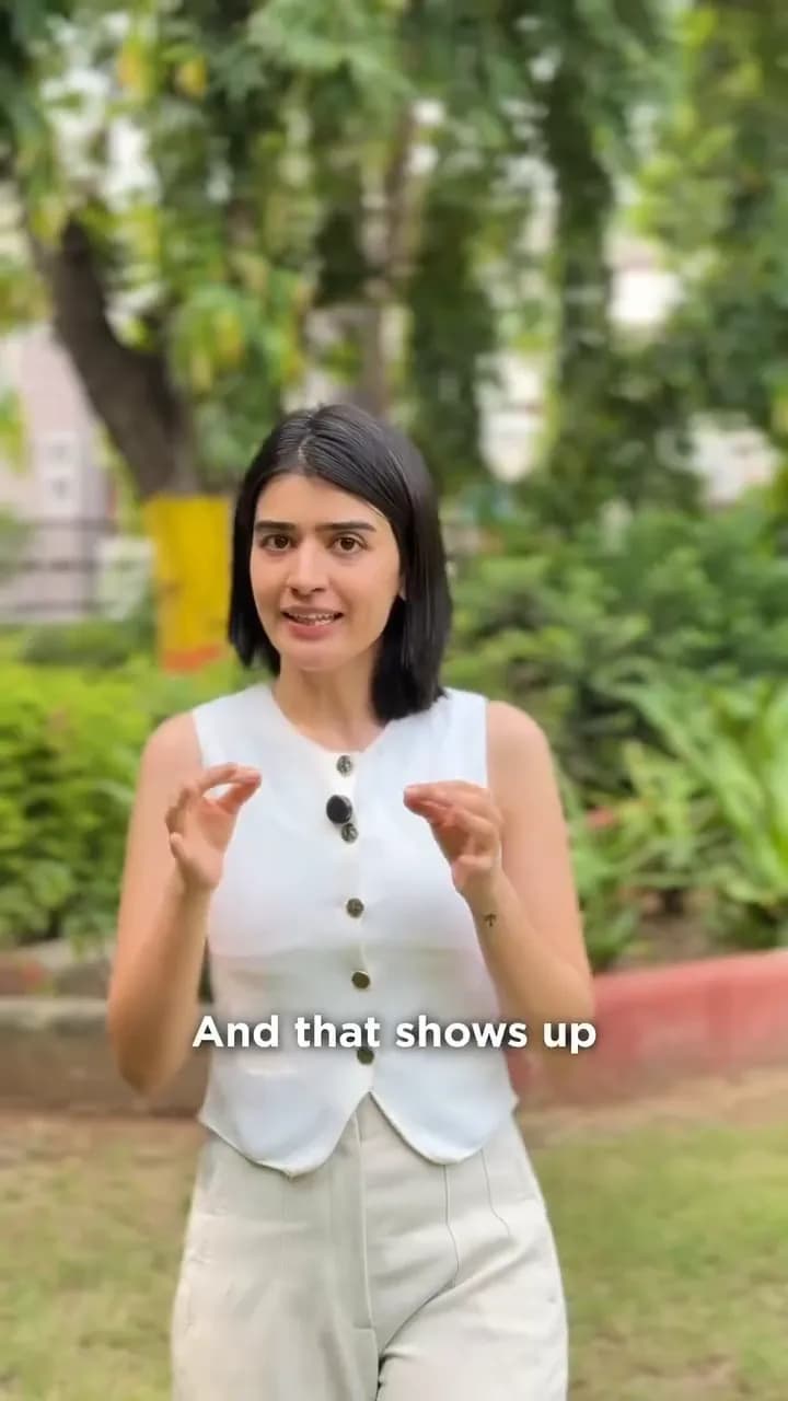 A creator in a white waistcoat speaks to camera in a garden.